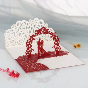 Détail d'une carte de mariage 3D avec roses découpées au laser et silhouette de couple
