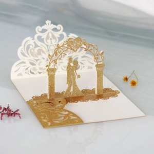 Macro detail of laser-cut 3D rose wedding invitation with golden glitter and couple silhouette