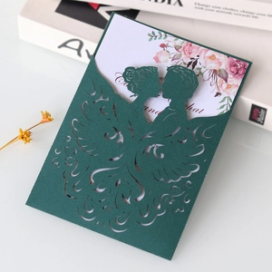 Elegant laser-cut dark green wedding invitation with floral insert card on white desk