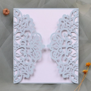 Macro view of laser-cut lavender wedding invitation with intricate lace floral patterns