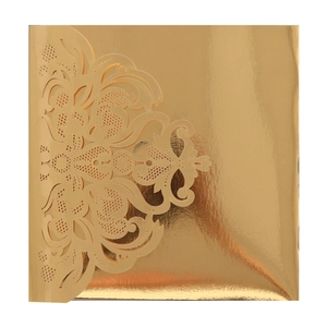 Detail of laser-cut lace pattern on gold shimmering wedding invitation cover