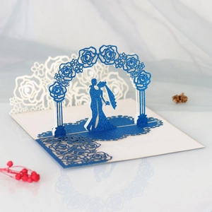 Macro shot of 3D pop-up wedding card with blue glitter laser cut groom and bride silhouette