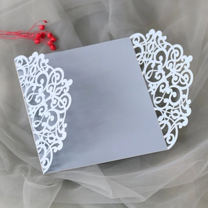 Detail of laser-cut wedding invitation with hollow floral vine pattern in light grey