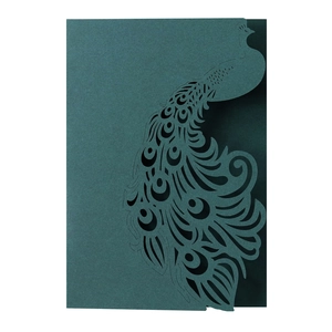 Detail of laser-cut peacock invitation card in deep cyan with intricate hollow patterns