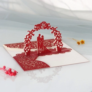 Détail d'invitation de mariage 3D avec couple découpé au laser sous une arche fleurie