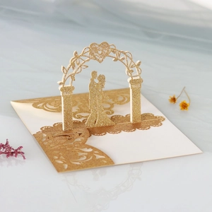 Detail of 3D pop-up wedding invitation featuring a golden glitter silhouette and floral arch