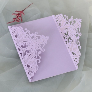 Macro shot of laser-cut floral details on lavender pearlescent wedding invitation card