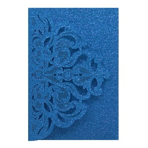 Close-up of laser-cut floral pattern on navy blue glitter paper wedding invitation
