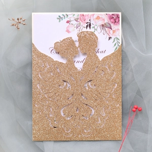 Detail of glitter gold laser-cut wedding invitation featuring bride and groom silhouette