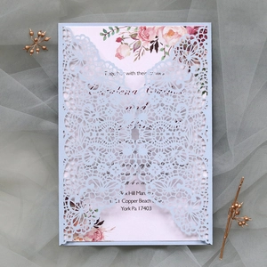 Détail de l'invitation de mariage en dentelle découpée au laser avec carte intérieure fleurie