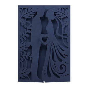 Close-up of laser-cut wedding invitation featuring a navy silhouette of a kissing couple