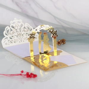 3D laser-cut wedding invitation featuring a romantic couple under a lace arch with gold details