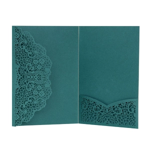 Detail of laser cut lace pattern on dark teal wedding invitation envelope