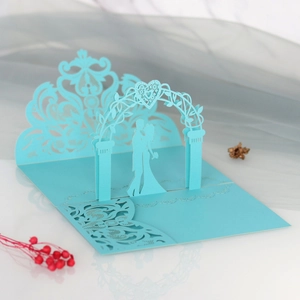 Macro view of 3D laser-cut light blue wedding invitation with couple and lace pattern
