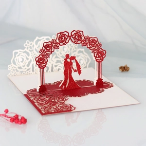Macro shot of 3D laser-cut wedding invitation featuring a glitter rose arch and couple silhouette