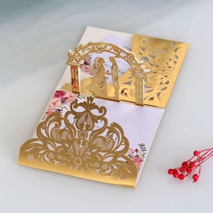 Detail of laser cut gold mirror wedding invitation with floral insert and gatefold arch