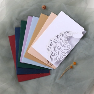 Detail of laser-cut peacock wedding invitations showing diverse elegant color options