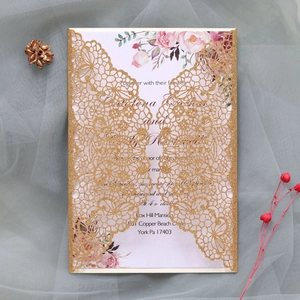 Detail of laser cut gold glitter wedding invitation with elegant floral inner sheet