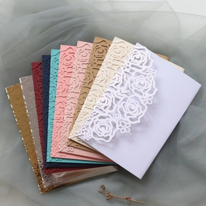 Detailed laser-cut rose patterns on multi-color wedding invitation envelopes in a fan layout