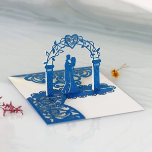 Detail of laser-cut 3D pop-up wedding card with navy blue glitter paper and couple motif