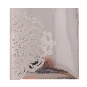 Macro shot of laser-cut silver mandala patterns on luxury square wedding invitations