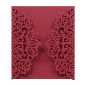 Detail of laser-cut burgundy invitation card with elegant European scroll patterns