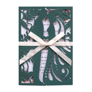 Detail of laser-cut wedding invitation with silhouette and cream silk ribbon bow
