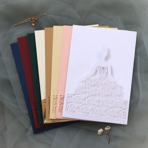Macro shot of laser-cut bridal gown and rose patterns on elegant wedding invitations