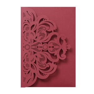 Detail of laser cut burgundy wedding invitation with elegant European vine pattern