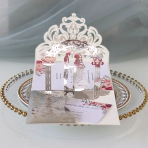 Detail of laser-cut wedding invitation featuring a 3D archway and romantic lace pattern