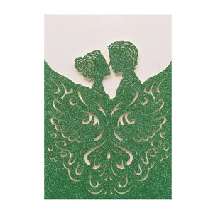 Detail of laser-cut green glitter wedding invitation featuring romantic couple silhouette