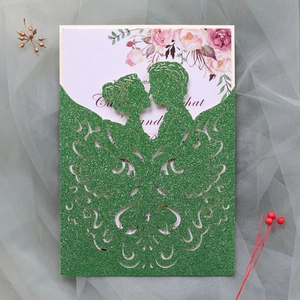 Detail of laser-cut glitter paper wedding card featuring butterfly and couple silhouette