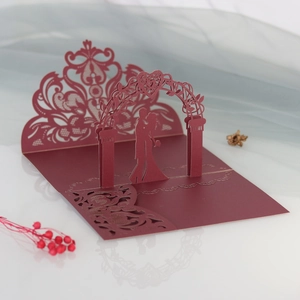 Detail of 3D laser cut wedding invitation showing a couple silhouette under heart arch