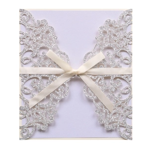 Silver glitter laser cut wedding invitation with elegant baroque patterns and ribbon