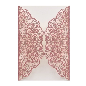 Close-up of laser cut floral lace hollow design on pink glitter wedding invitation paper