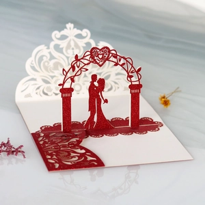 Detail showing 3D laser-cut wedding invitation with red glitter arch and couple silhouette
