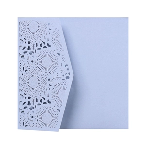Close-up of light blue laser-cut lace wedding invitation with intricate geometric patterns