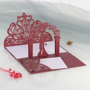 Macro view of 3D laser-cut wedding invitation featuring a couple under a floral arch