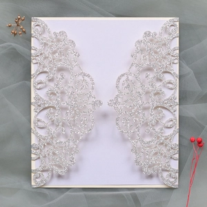 Detail of silver glitter wedding invitation card with laser cut floral pattern