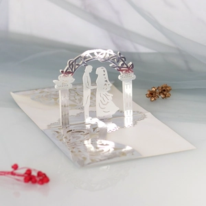 Detailed laser cut 3D wedding invitation featuring silver glitter gate and couple silhouette