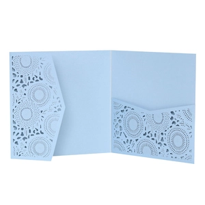 Detail showing laser-cut light blue invitation cover with intricate floral mandala patterns