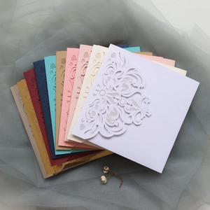 Macro detail of laser-cut floral pattern gatefold wedding invitations in diverse colors