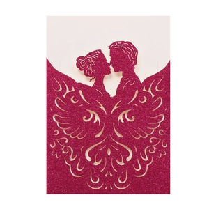 Macro view of laser-cut glitter paper wedding invitation with couple and butterfly wings