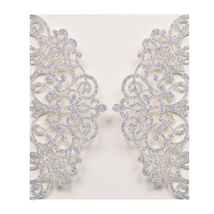 Detailed close-up of laser-cut silver lace invitation with glittery floral pattern