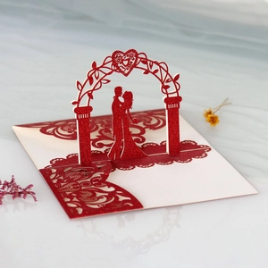 Detail of 3D laser-cut wedding invitation showing a romantic couple and floral archway