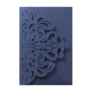 Macro detail of navy blue laser-cut lace invitation with intricate baroque floral patterns