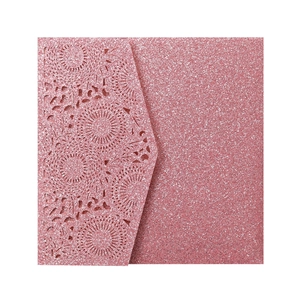 Détail macro du faire-part de mariage en papier pailleté avec motif de dentelle au laser