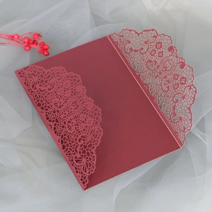 Détail d'un faire-part de mariage bordeaux avec dentelle découpée au laser élégante