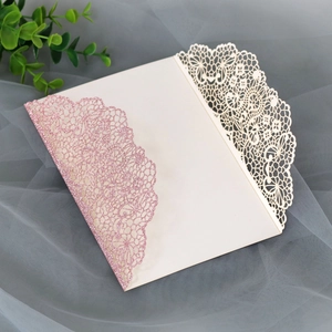 Detailed laser cut lace texture on pink glitter and ivory wedding invitation card
