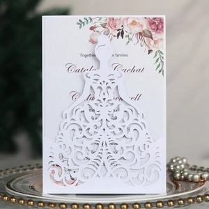 Macro detail of laser-cut lace wedding invitation with floral inner card on porcelain
